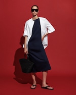 Placeholder for: Red background with mauve dress with white button up and sandals with large oversized sunglasses