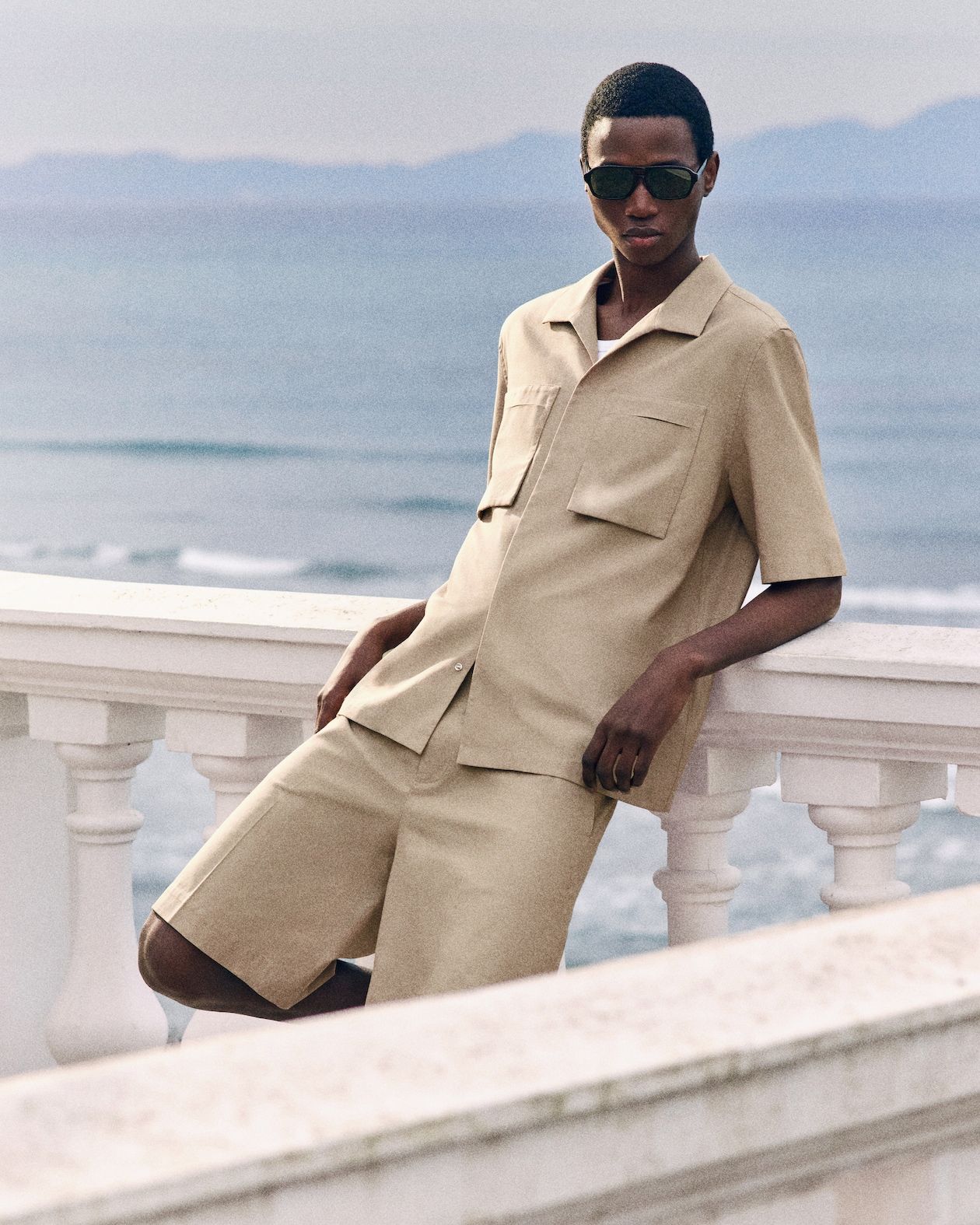 person wearing a beige utility shirt with matching shorts