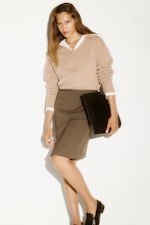 Placeholder for: Women in cream jumper with shirt and black bag