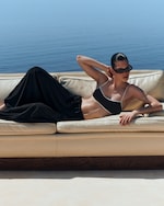 Placeholder for: woman on sofa in bikini and black trousers