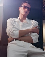 Placeholder for: man in white shirt leaning back in chair wearing sunglasses