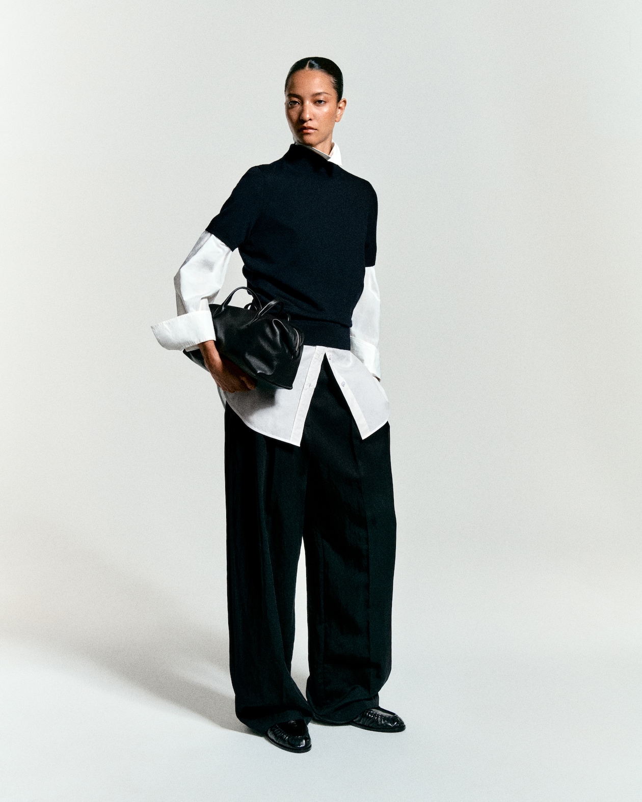 Black trousers with a white button up and black tight shirt on top