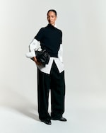 Placeholder for: Black trousers with a white button up and black tight shirt on top