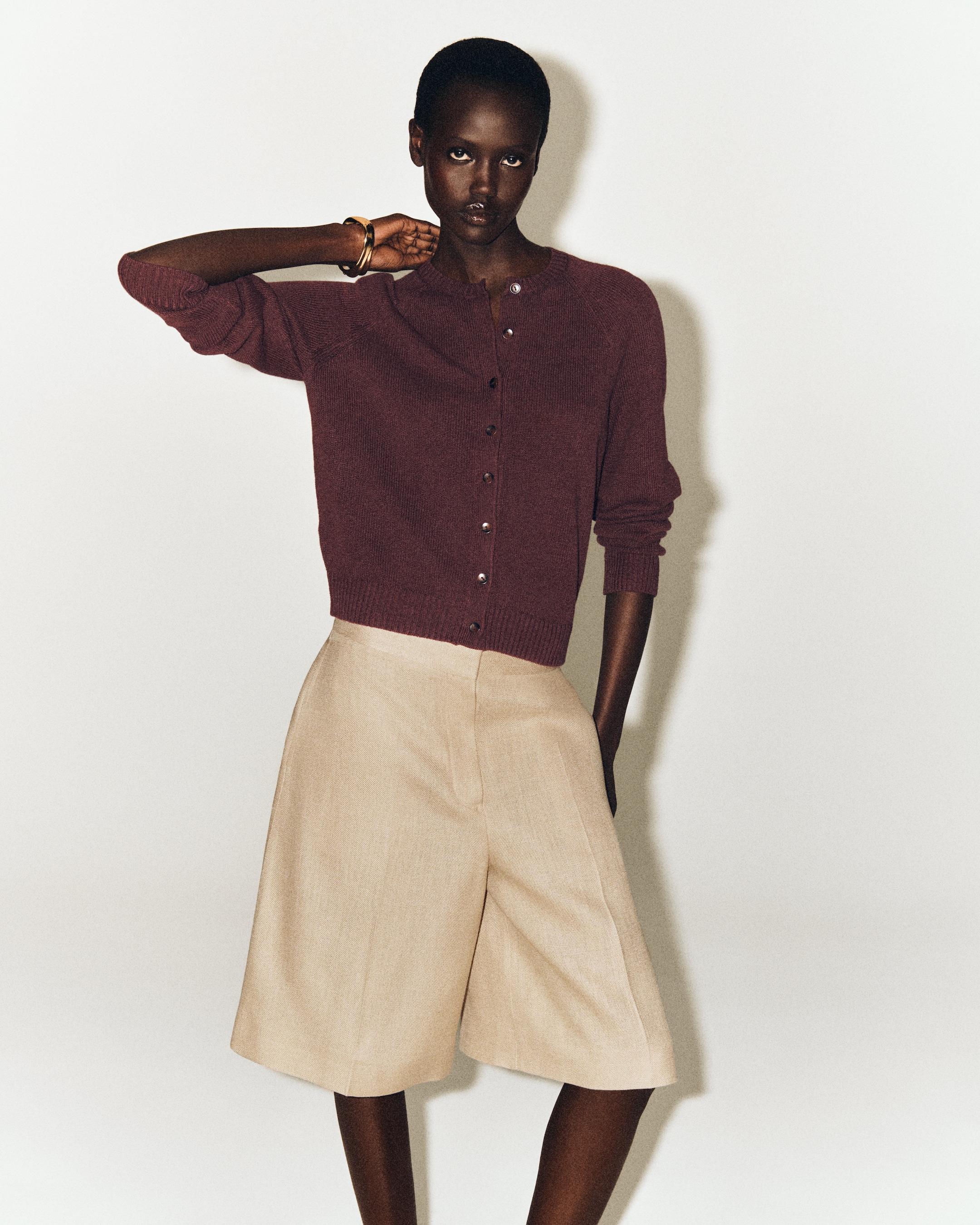 woman in burgundy linen cardigan and shorts