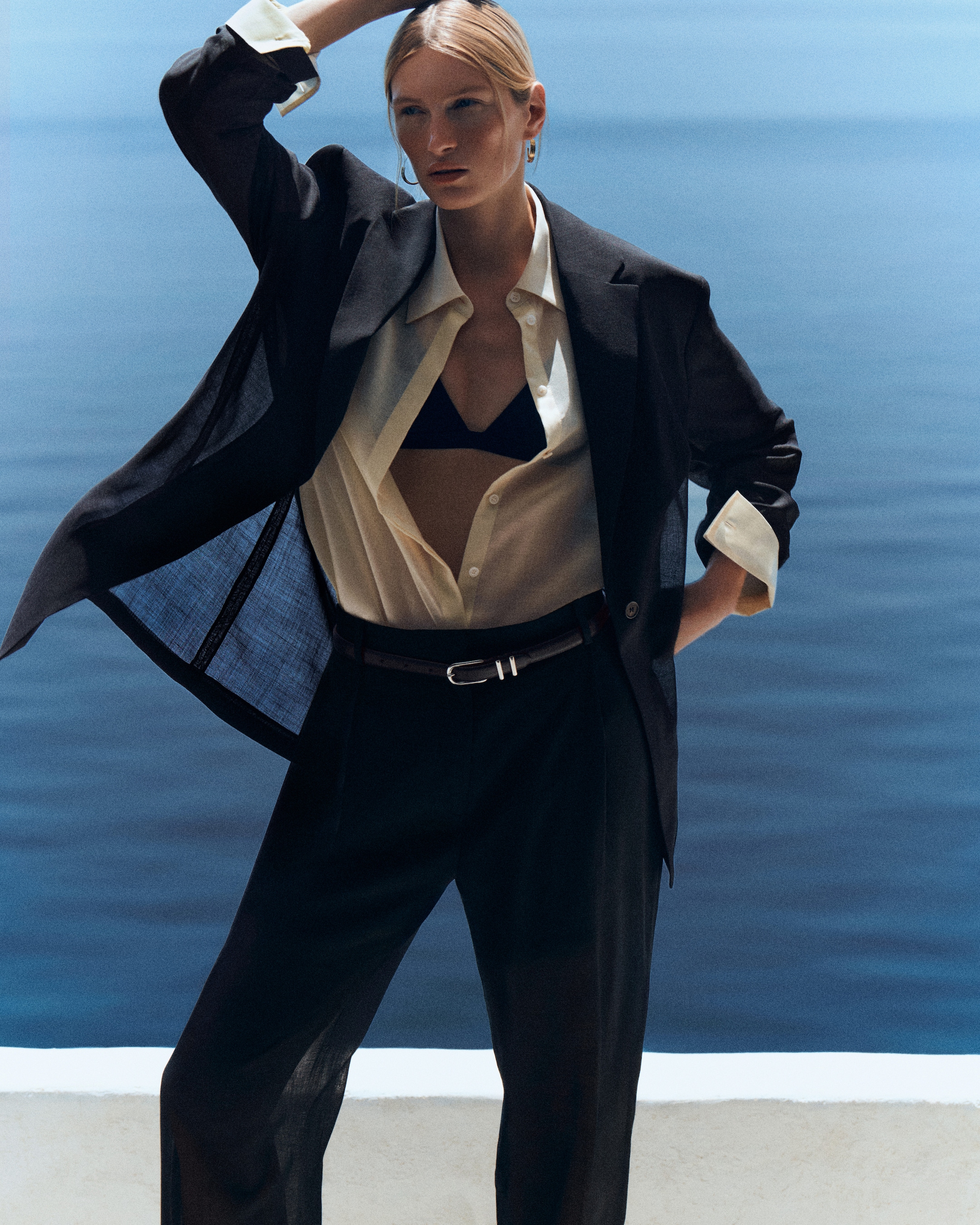 Woman in white sheet shirt with sheer blazer on top