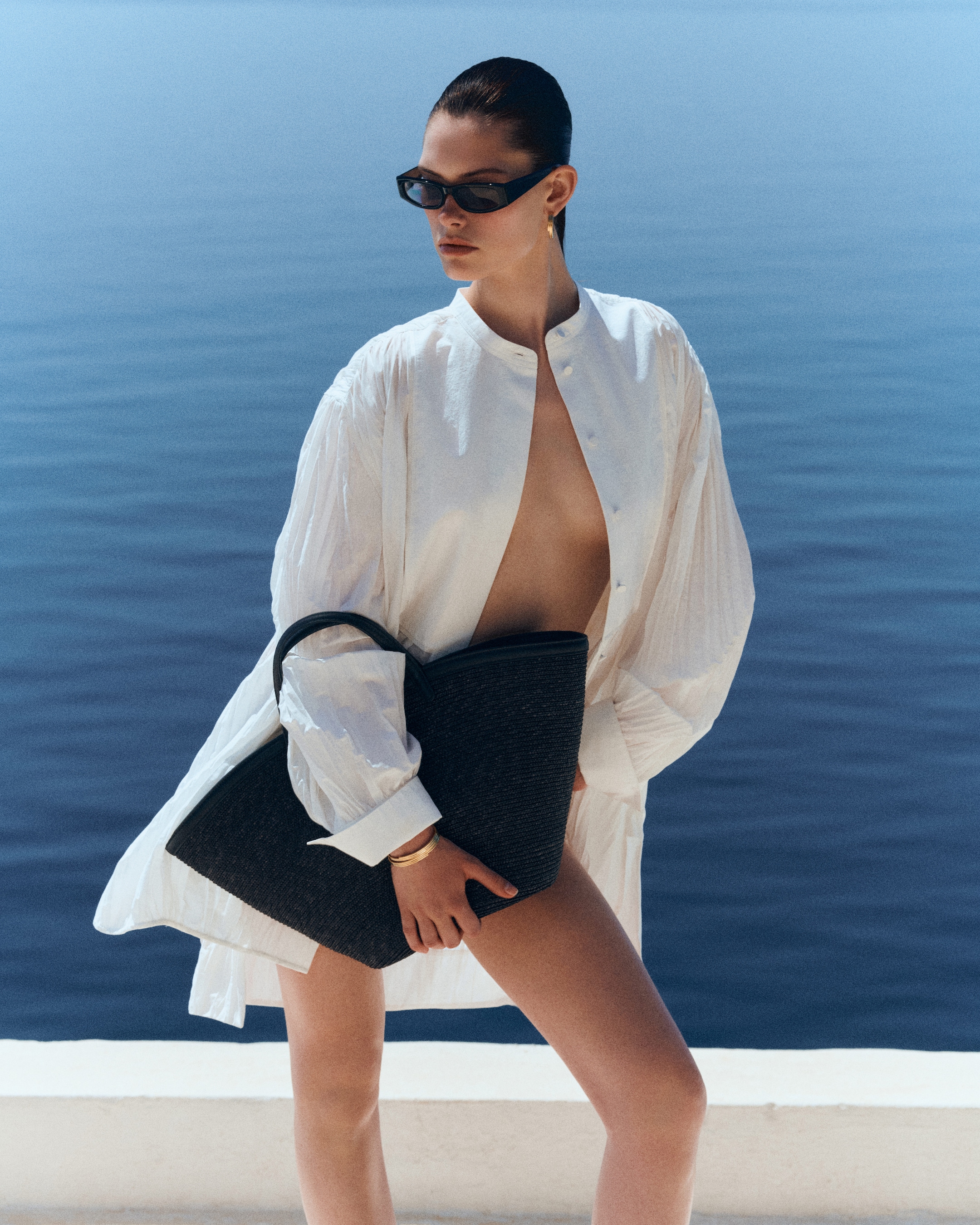 woman in white shirt holding black bag