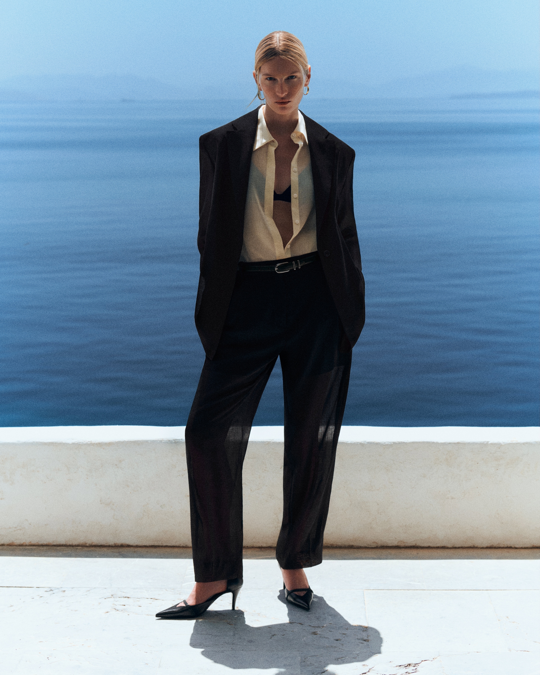 woman in black linen suit by the sea
