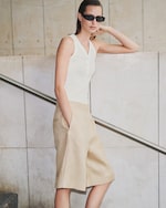 Placeholder for: model wearing white vest top and beige linen shorts