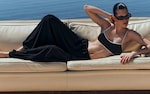 Placeholder for: woman in black and white bikini top and black trousers