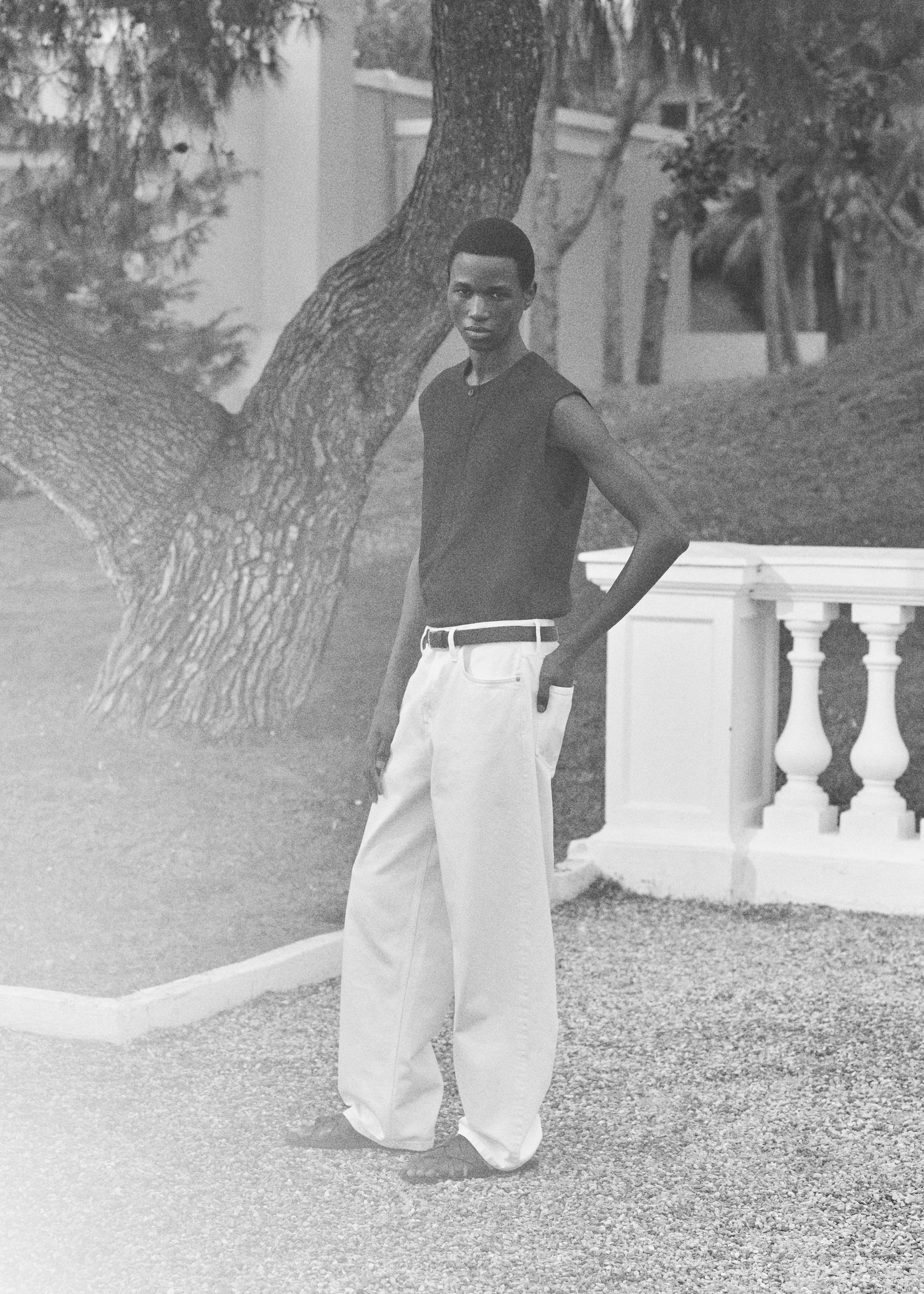 man in white jeans and black vest