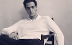 Placeholder for: person sitting in a chair with a white knit polo shirt