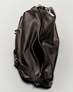 Placeholder for: A brown leather duffel bag with zippers and adjustable strap, slightly open, lying on a light gray surface.