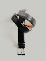 Placeholder for: A black leather belt with a silver buckle, artistically twisted into a spiral shape, set against a light gray background.