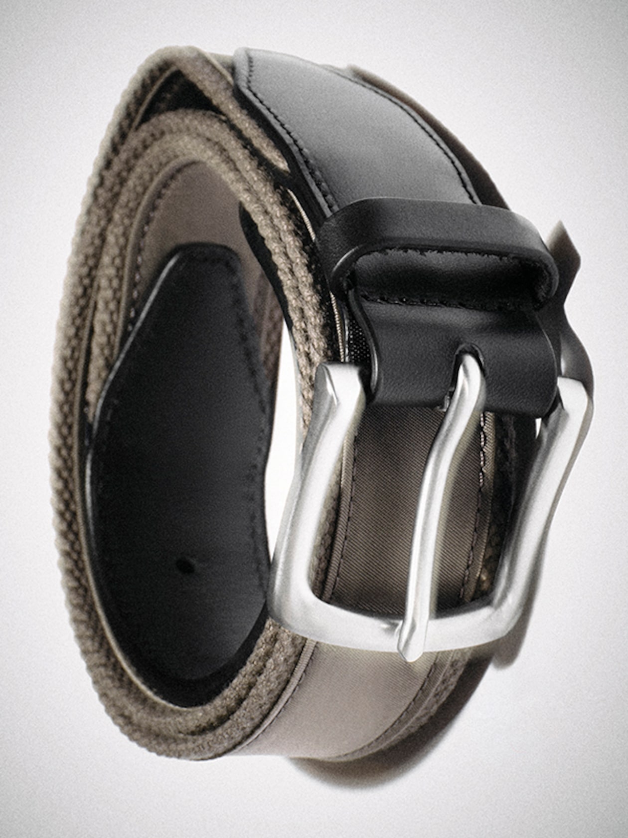 Rolled beige and black leather belt with silver buckle, showcasing the texture of the belt and sleek design of the buckle.