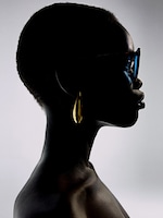 Placeholder for: Silhouette of a person with short hair wearing sunglasses and a large gold earring, set against a gradient background.