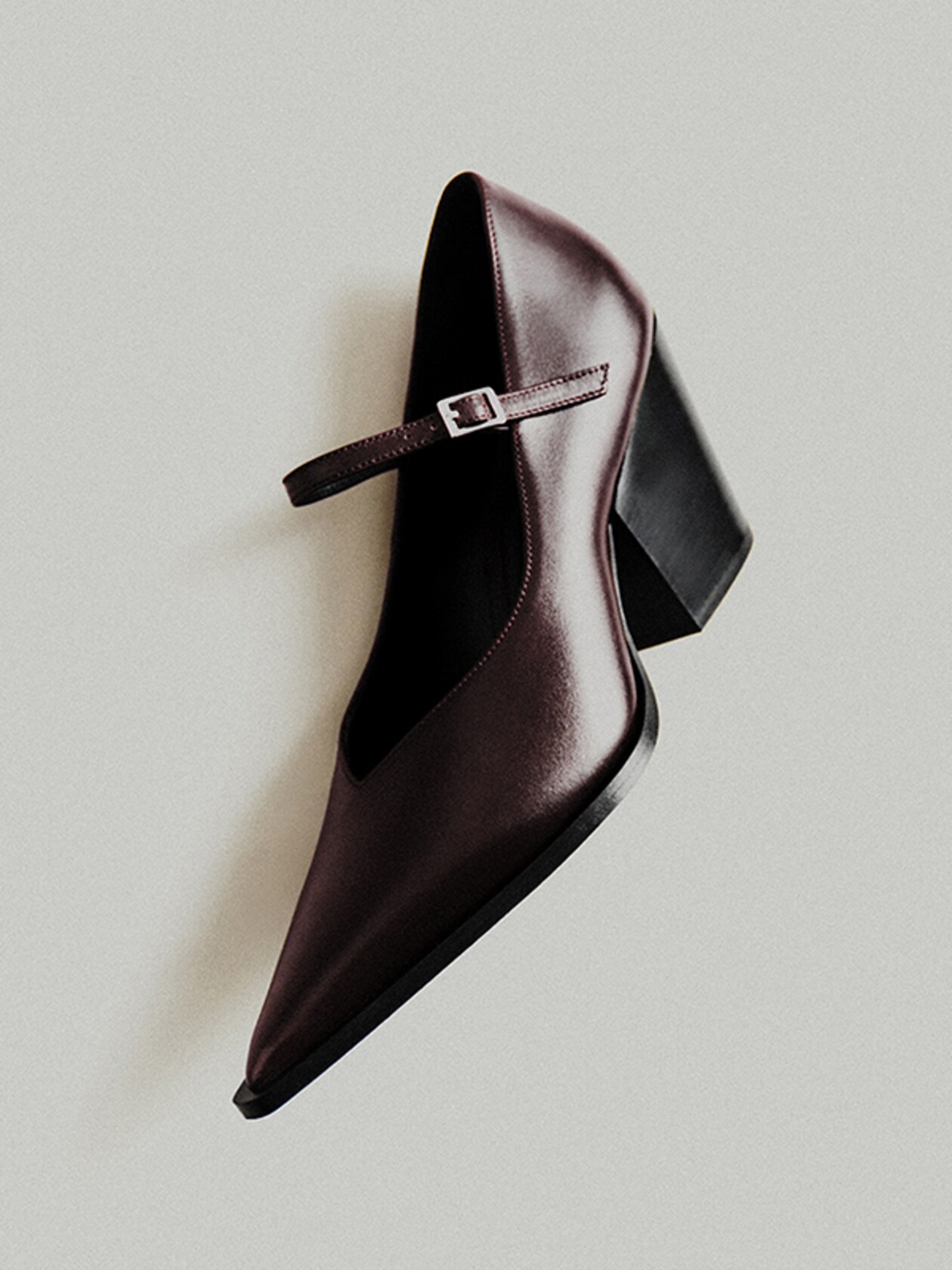 Maroon leather Mary Jane shoe with a chunky black heel and buckle strap, displayed against a light gray background.