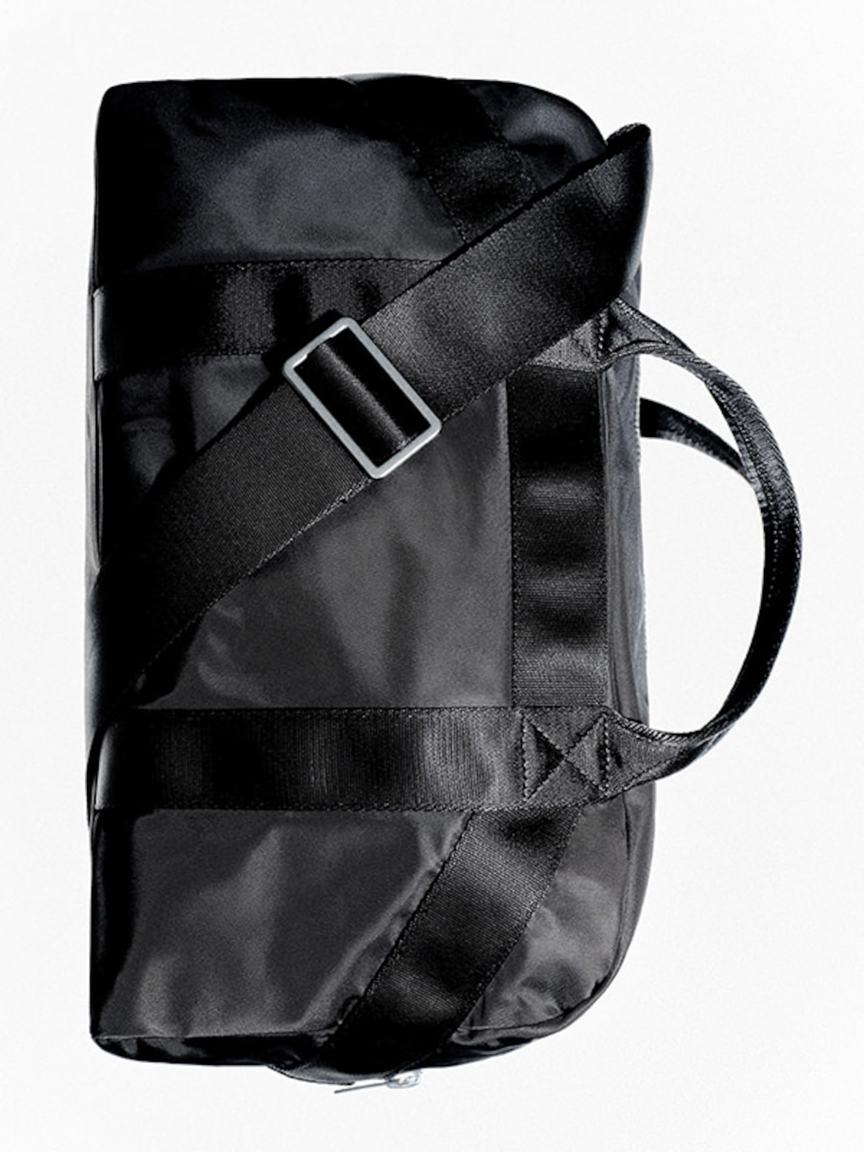 Black duffel bag with a long adjustable strap and handle, showcasing a sleek and compact design against a white background.