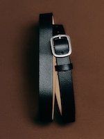 Placeholder for: A black leather belt with a silver rectangular buckle displayed on a brown background.