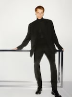 Placeholder for: man leaning on a table in a dark suit
