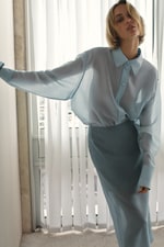Placeholder for: Woman in blue sheer shirt and skirt