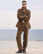 Placeholder for: Person in sunglasses wearing a brown suit and sandals