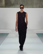 Placeholder for: woman in brown sleeveless top black trousers and sunglasses