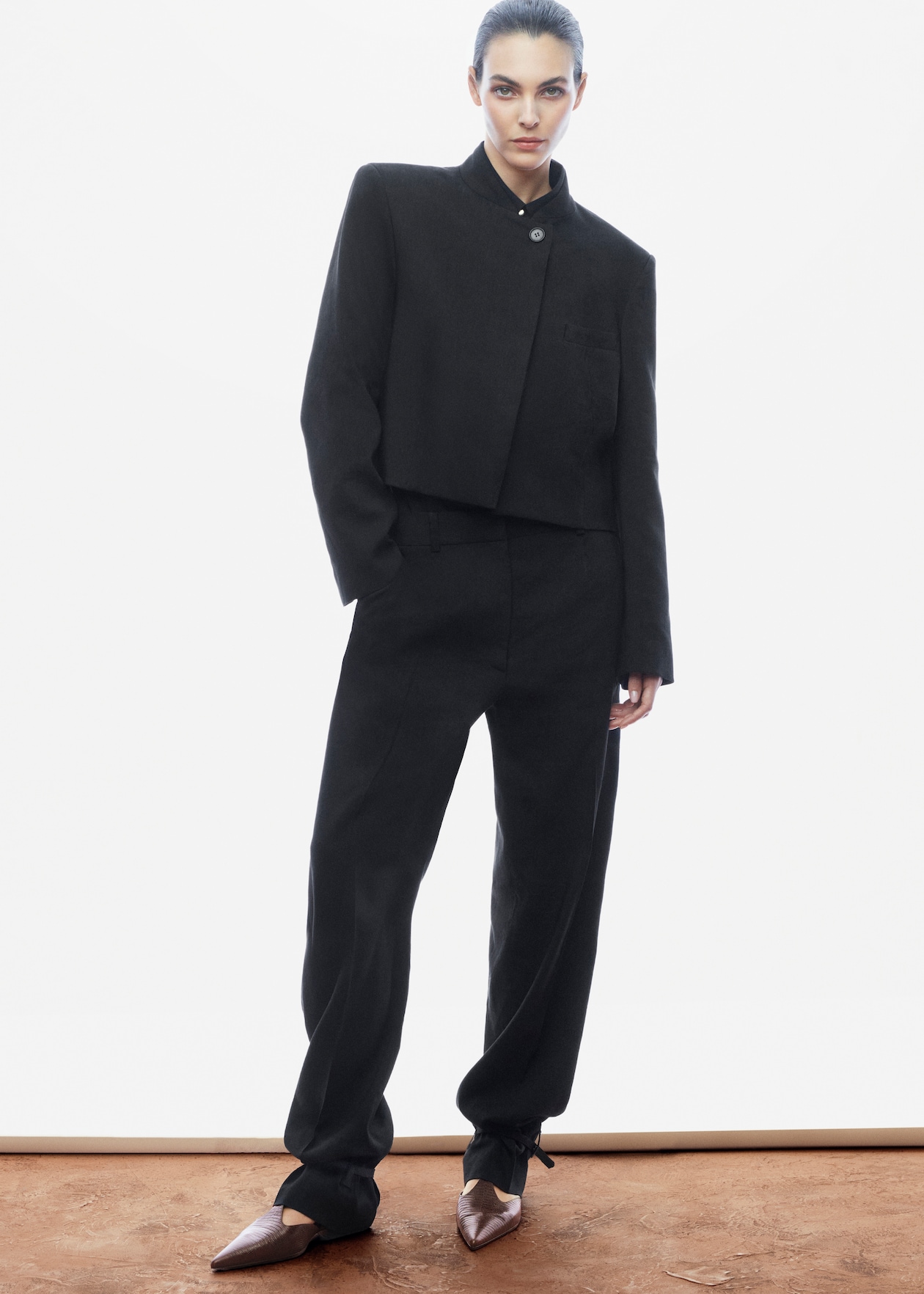 woman in black cropped suit jacket and trousers