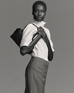 Placeholder for: Woman in blouse holding bag