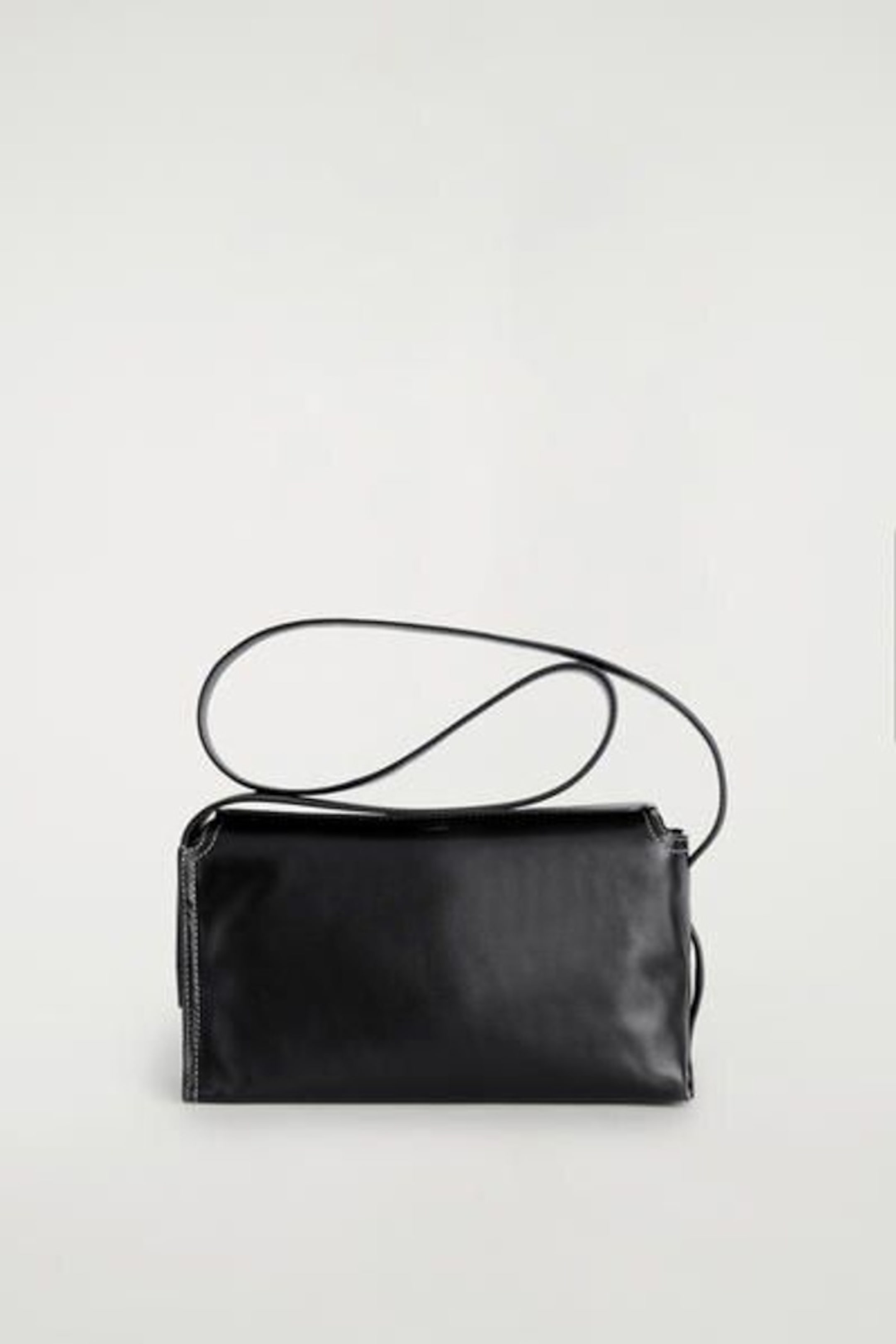 A sleek black leather handbag with a long strap, shown against a plain light gray background.