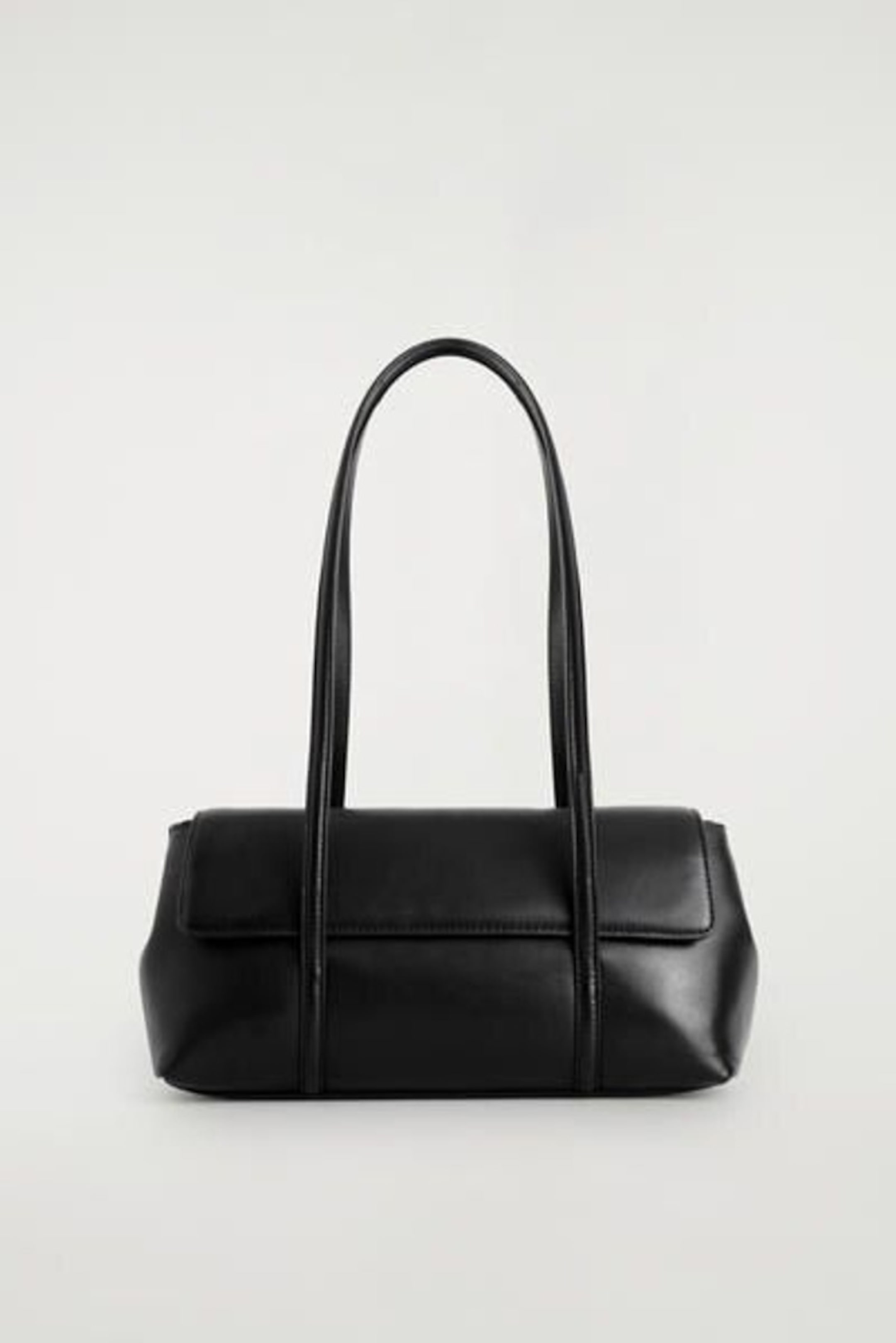Black rectangular handbag with two long straps, minimalistic design, and a flat base, set against a plain background.