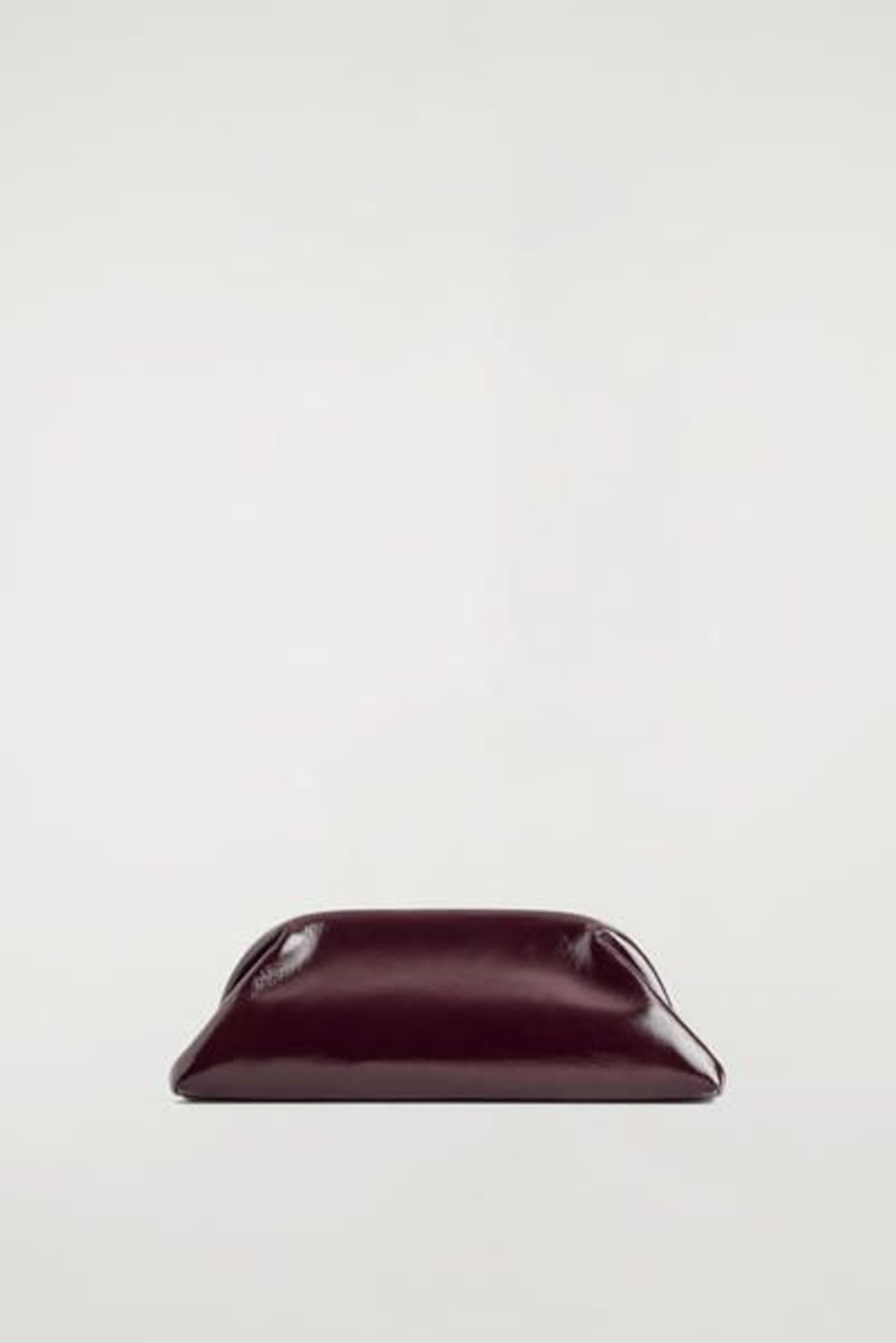 A sleek, dark brown leather clutch purse with a smooth finish is centered on a plain white background.
