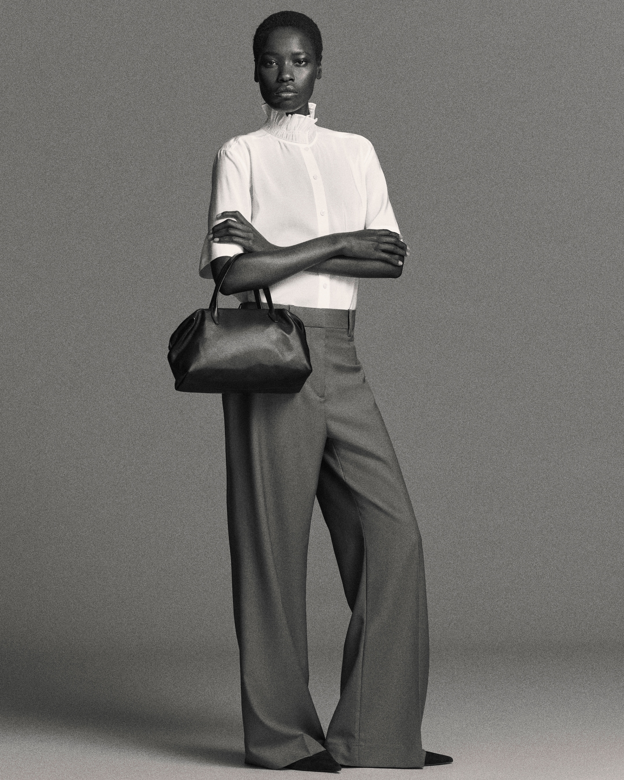 Woman in blouse and trousers with arms crossed