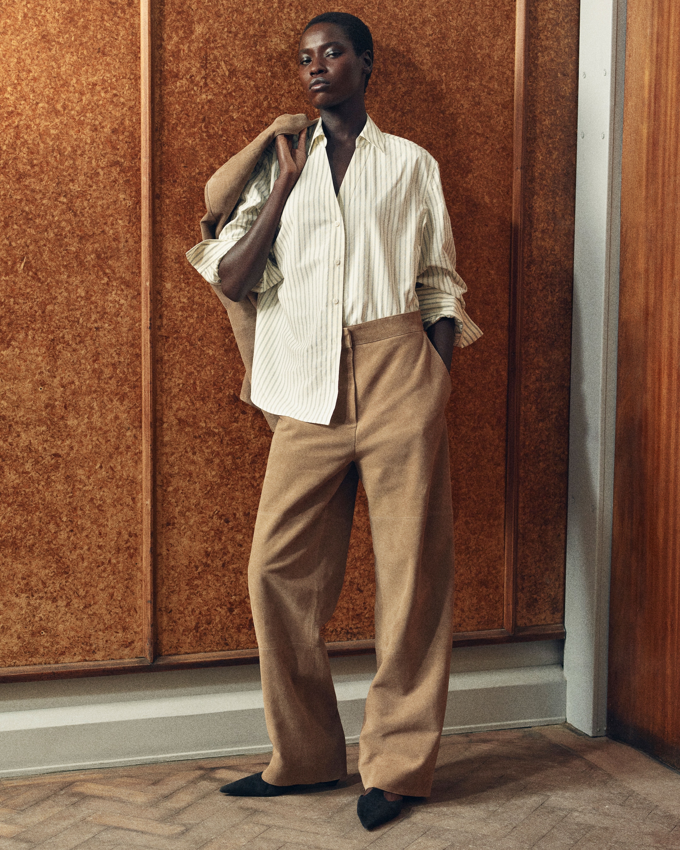 Woman wearing pinstripe shirt with beige trousers