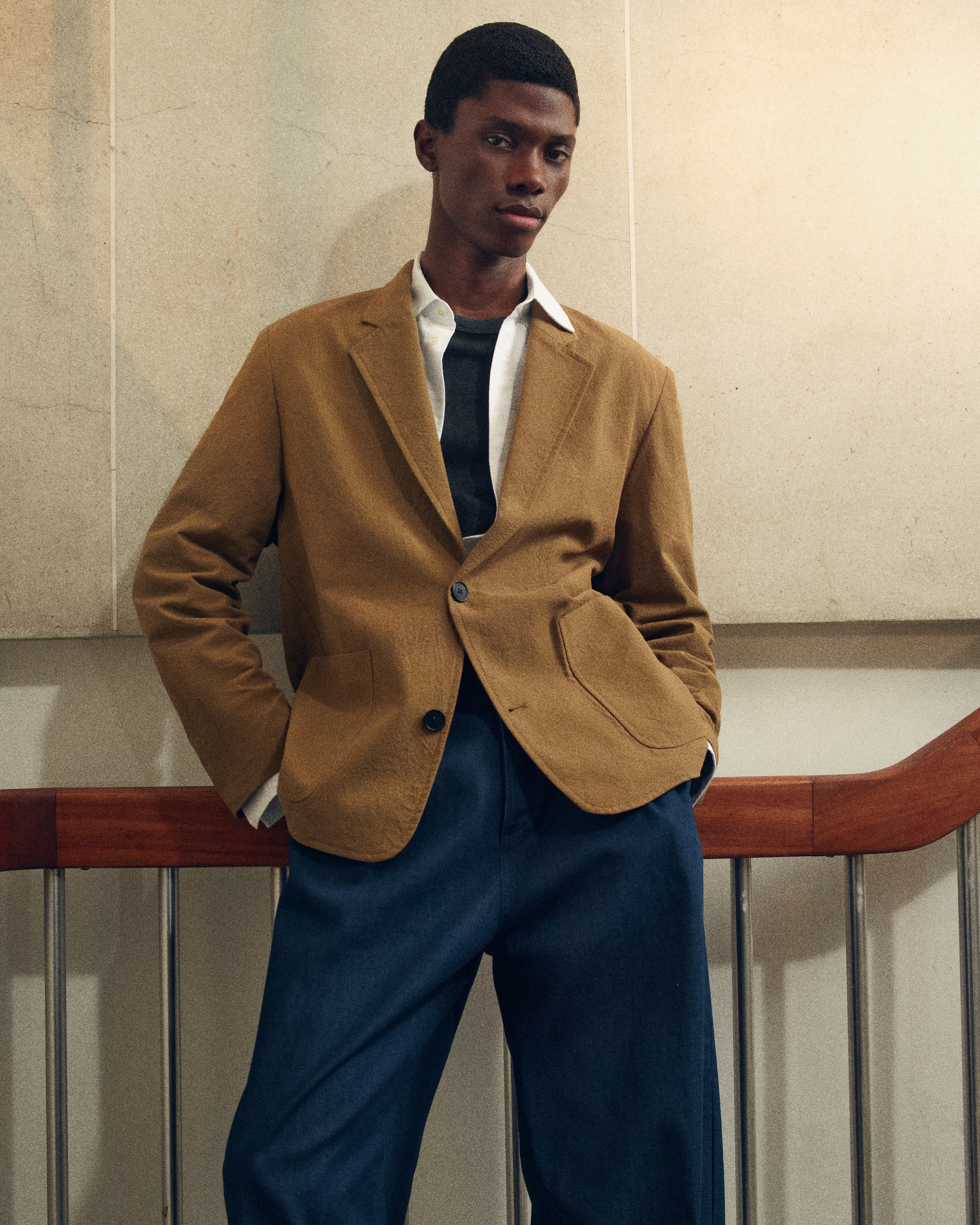 man in blue jeans and brown blazer