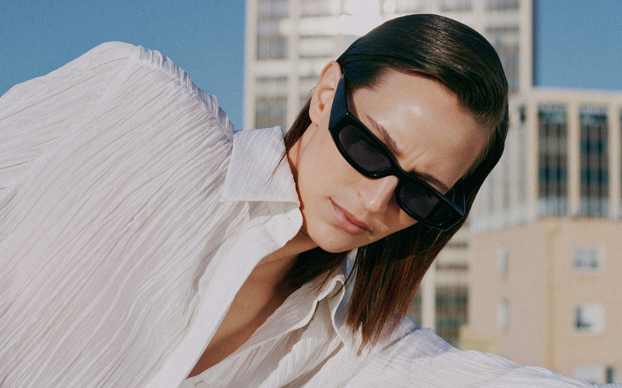 woman in white crinkled shirt dress with sunglasses