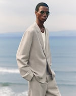 Placeholder for: person wearing a light coloured linen blazer and sunglasses