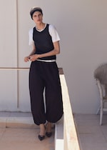 Placeholder for: woman in white tshirt, navy tank top and black balloon trousers