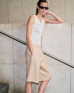 Placeholder for: women in vest wearing baggy beige shorts