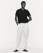 Placeholder for: man wearing navy polo shirts and white relaxed denim trousers