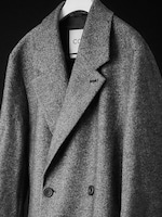 Placeholder for: Black and white image of a herringbone coat hanging
