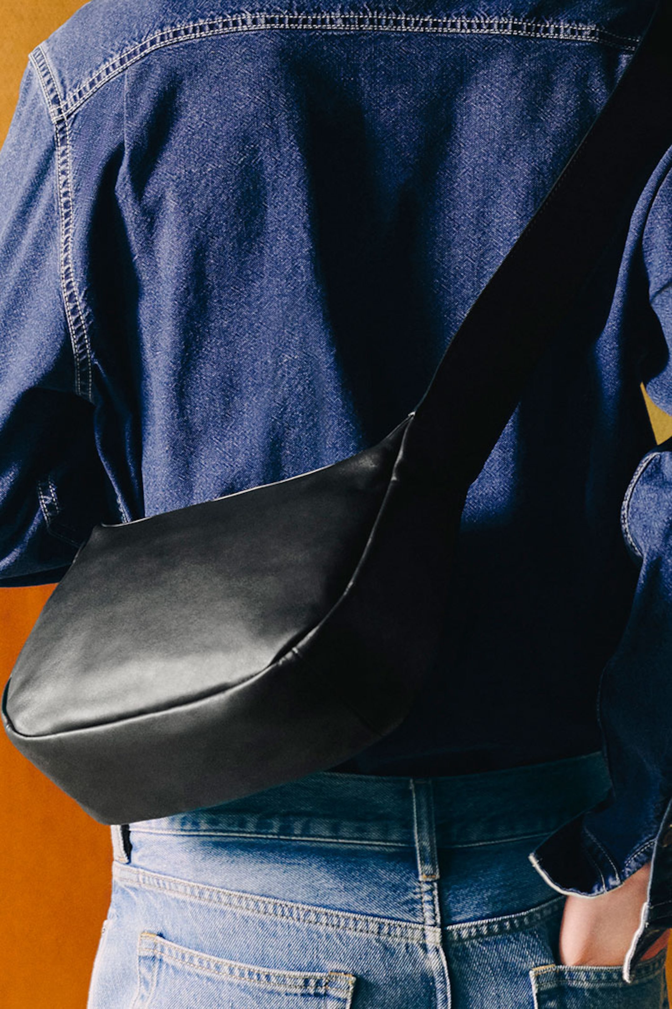 person holding crossbody leather bag