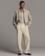 Placeholder for: man standing wearing grey melange shirt and matching zip up blouson and belted trousers