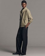 Placeholder for: man standing wearing khaki blouson and pinstripes black trousers