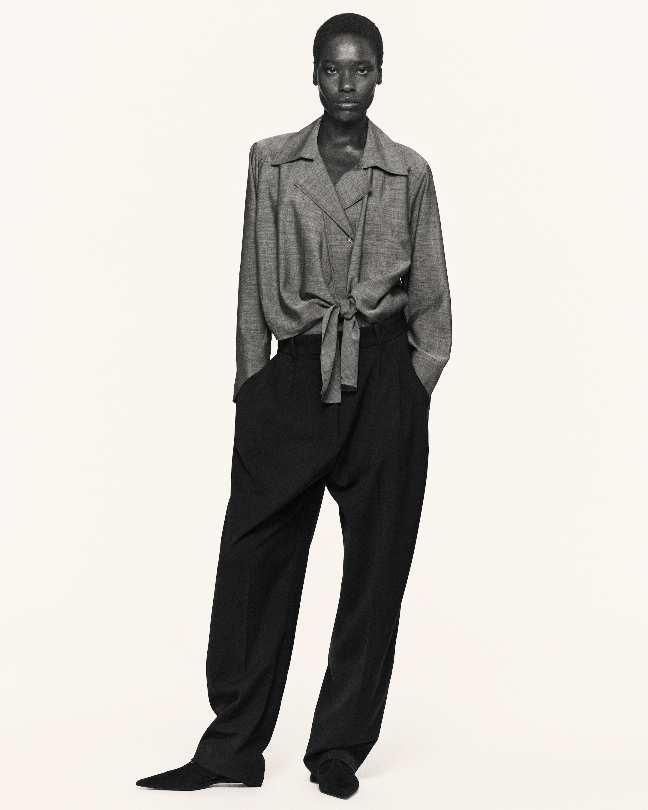 Woman in tie waisted blouse and black trousers