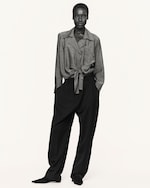 Placeholder for: Woman in tie waisted blouse and black trousers