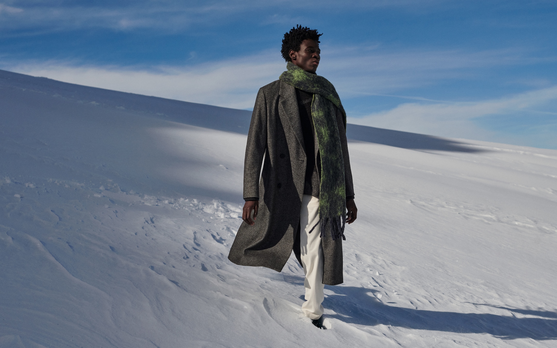 Man wearing long wool coat and scarf