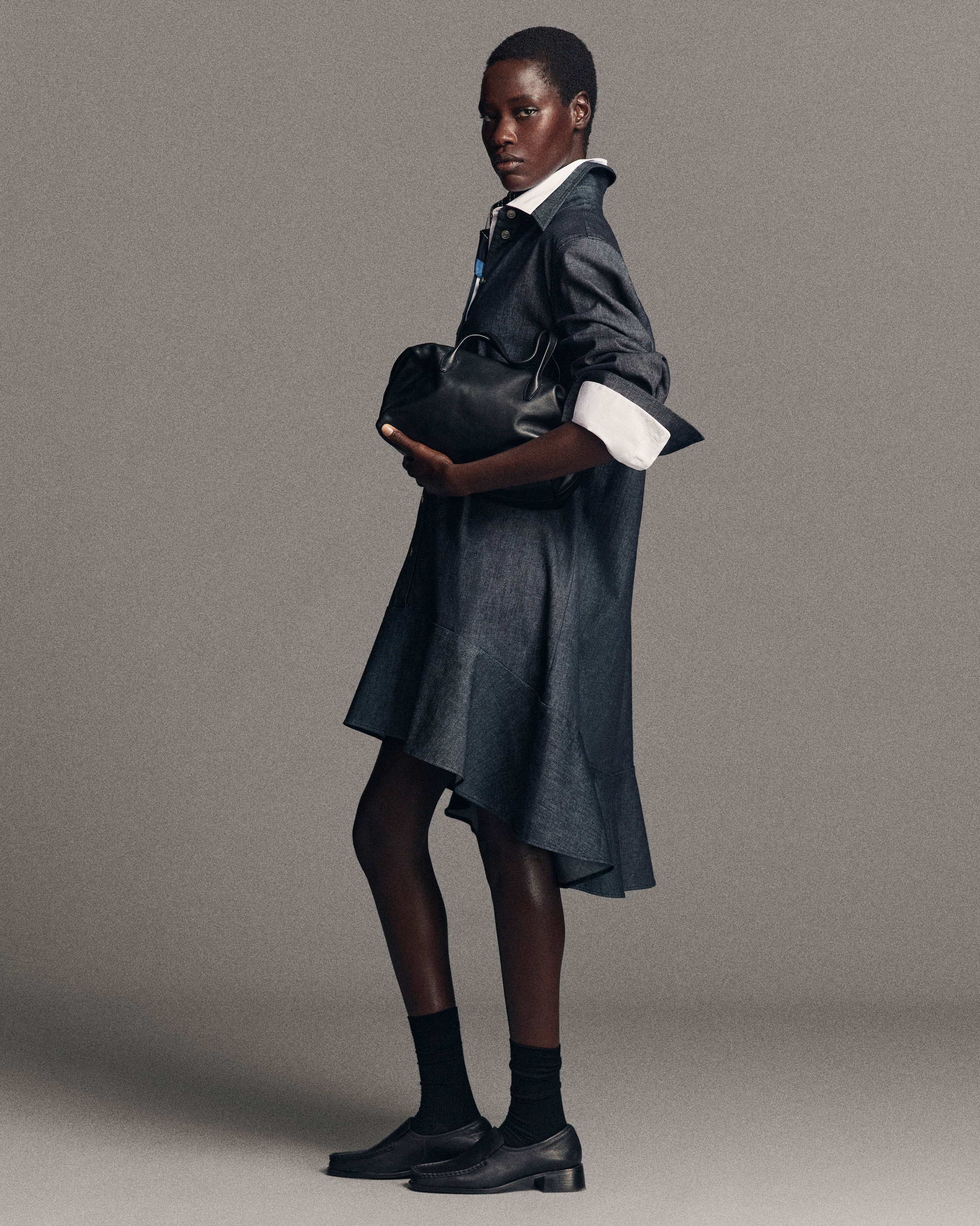 Woman in denim dress holding bag