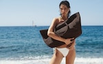 Placeholder for: model wearing white bikini holding brown beach bag
